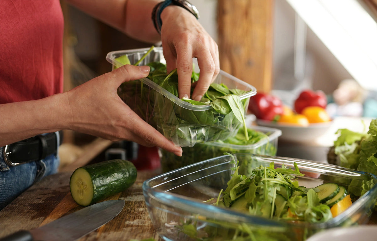 Fresh vegetables and leafy greens being prepared in a home kitchen.
